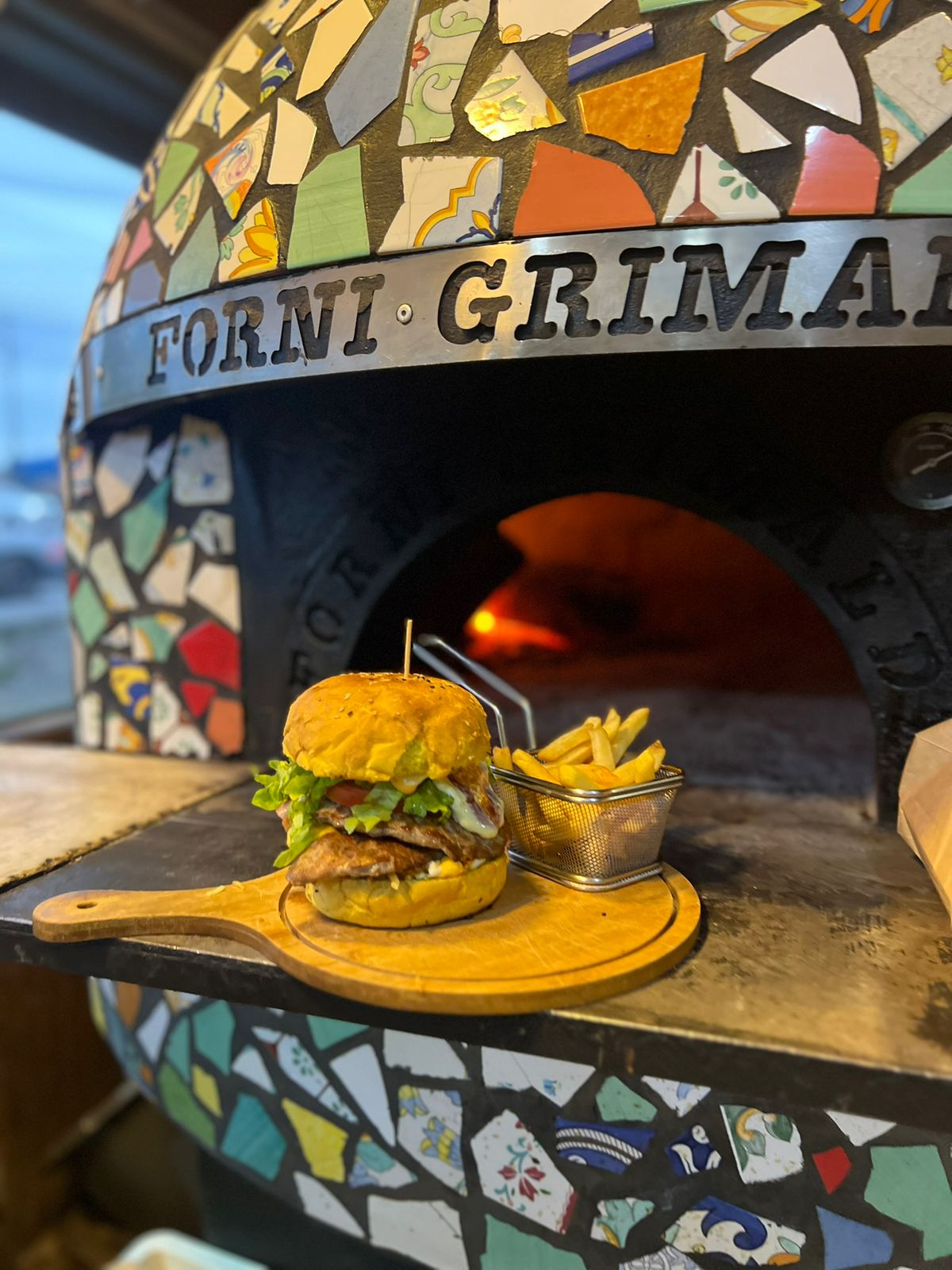 Hamburguesa y papas fritas recién salidas del horno a leña de Fuego Sureño